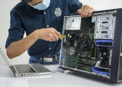 A technician repairs a desktop computer in an indoor setting, illustrating tech maintenance.